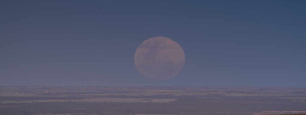 The moon comes up over the horizon to the East over Mannum, South Australia